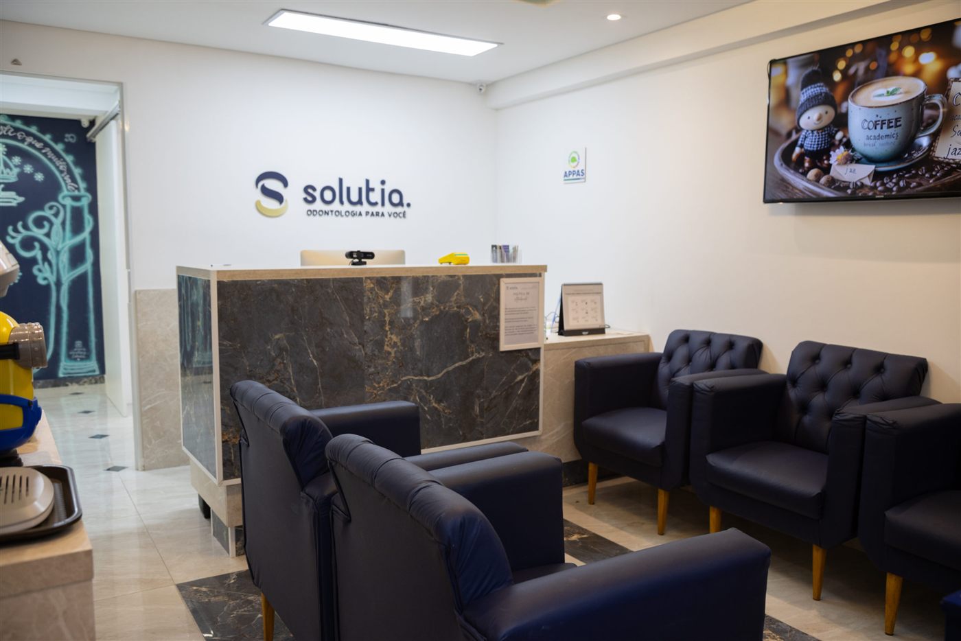 Recepção da Solutia com balcão de mármore e poltronas